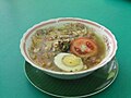 Soto ayam dengan tambahan telur dan tomat mentah.