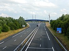 La chaussée de l'autoroute A837, vue depuis un pont qui la surplombe. En arrière-plan, la barrière de péage de Cabariot.