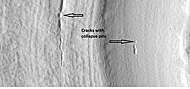 Close-up showing cracks containing pits on the floor of a crater containing concentric crater fill, as seen by HiRISE under HiWish program. Location is the Casius quadrangle.