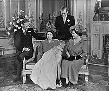 An infant Charles in a white christening gown with his parents and grandparents