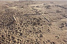 Photographie aérienne en couleurs de ruines dans le désert.