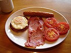 イギリス（やアメリカ）での典型的な朝食の一種。目玉焼き + ベーコン・ソーセージ類 + 焼きトマト。