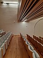 Detail koncertního sálu s dřevěným podhledem a sedadly