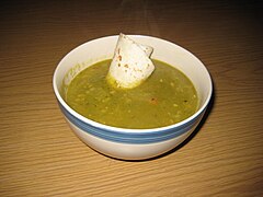 A thick pea soup garnished with a tortilla accent