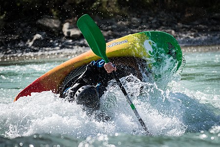 Kayaker playboating on the Durance river (France).