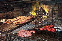 Table with a cut of Argentine beef, wine, sauces and spices