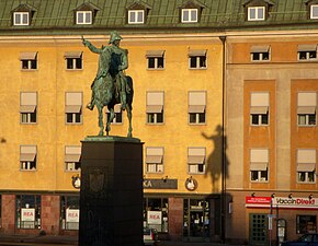 Karl XIV Johans staty och skuggan på Räntmästarhuset.