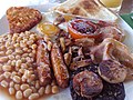 Image 37The full breakfast is among the best known British dishes, consisting of fried egg, sausage, bacon, mushrooms, baked beans, toast, fried tomatoes, and sometimes white or black pudding. (from Culture of the United Kingdom)