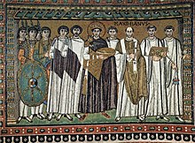 Kaiser Justinian ist in der Bildmitte durch eine dunkle Toga und einen Kreis um seinen Kopf gekennzeichnet. Links von ihm (für den Beobachter rechts) sind vier Kleriker dargestellt, darunter im Vordergrund eine Person, die mit der Inschrift „Maximianus“ gekennzeichnet ist. Direkt rechts von ihm sind zwei Männer in einer weißen Toga, darunter Belisar, der einen Schnurrbi trägt. Weiter rechts steht eine Gruppe von fünf Soldaten mit Schildern und Speeren.