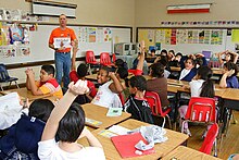 Man teaching a full classroom