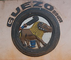 Bilde av et rundt relieff, som viser en bøffel. Relieffet er fargelagt