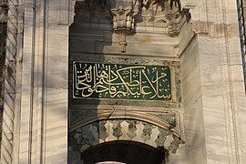 Una inscripción caligráfica encima de una puerta de la mezquita