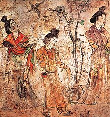 Malba (barevná s černými obrysy postav a věcí) tří stojících žen v tradičním čínském oděvu, s vlasy vyčesanými do drdolů, prostřední žena stromek nad kterým poletuje pták