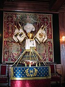 Photographie en couleurs d'un berceau de bébé dans une pièce décorée de tentures et d'étendards.