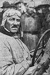 Photo d'André Morel posant au volant de sa voiture.