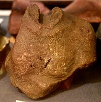 Headless bust of Akhenaten or Nefertiti with four pairs of early form Aten cartouches, once part of a composite red quartzite statue with indications of Intentional damage. Amarna, Egypt. New Kingdom, late 18th Dynasty. The Petrie Museum of Egyptian Archaeology, London