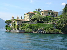 Photo d'une riche villa arborée près d'un lac.
