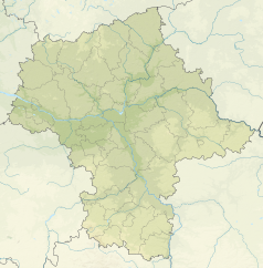 Mapa konturowa województwa mazowieckiego, w centrum znajduje się czarny trójkącik z opisem „Kopiec Powstania Warszawskiego”