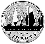 The obverse of a coin, showing the bottom third of three people dressed in military-style pants and boots: a person with two legs, a person with two legs and a crutch, and a person with one leg and a prosthetic leg. The words "They Stood Up For Us", "In God We Trust", "2010", and "Liberty" embellish the coin.