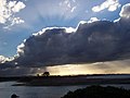 分厚い雲を挟んで上下に差す薄明光線、ニュージーランド北部の町ファカタネにて