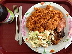 Riz wolof cuit à la ghanéenne accompagné de coleslaw et de poulet cuit au barbecue