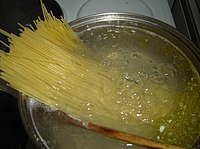 Mỳ Ý đang được cho vào nồi nước sôi để nấu