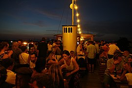 Party guests on the upper deck having a view over nightly Sendling