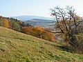 Pohled z Bartoňovy hory na Vrchmezí, ve středním plánu bezejmenný vrch (cca. 550 m n. m.) nad městem Kudowa-Zdrój (Chudoba) v Levínské vrchovině