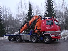 Un porteur type plateau à grue de levage (Finlande).