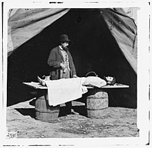 Embalming surgeon at work on soldier's body