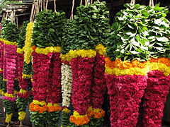 Malais (colliers de fleurs) suspendus dans un stand de fleuriste au marché.