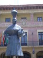Monument a la dona de faldetes amb l'ajuntament al fons. Representada amb cantàrs per recordar el costum d'anar a recollir aigua al riu Cinca