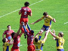 Un joueur de dos réceptionne le ballon lors d'un alignement en touche.