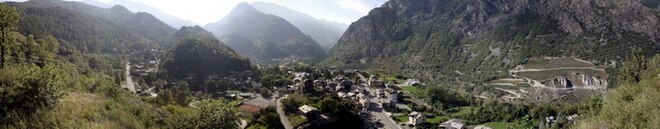 Photographie panoramique d'un village au fond d'une vallée.
