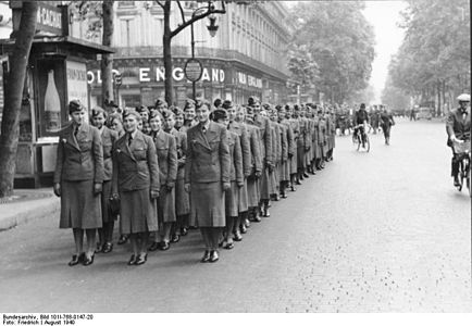 Au début de l'occupation allemande, en août 1940, auxiliaires féminines de transmissions défilant sur le boulevard des Capucines (en arrière-plan, le magasin Old England, une des enseignes emblématiques de l'artère, de 1867 à sa disparition en mars 2012).