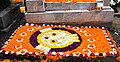 Gravesite ornately decorated with flowers and flower petals with image of skull