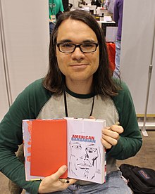 Scioli holding a comic and smirking
