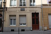 Photo de la façade de la maison natale de Paul Michaux avec plaque commémorative au fronton de la fenêtre centrale.