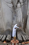 A Jain woman washes the feet of Bahubali Gomateswara at Shravanabelagola, Karnataka. The Bahubali idol is 18 metres (58 ft) high and is carved out of a single rock on top of a hill.