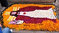 Gravesite decorated with image of Jesus done in flower petals