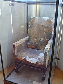 Photo récente du fauteuil dans une vitrine de musée.