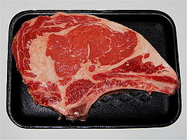 A rib steak, raw, with bone attached (côte de bœuf)