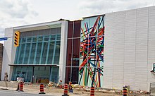 Main entrance of Oakwood station depicting a photograph of colourful pick-up sticks on a white background