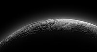 פלוטו בשקיעה. בתצלום ניתן להבחין באזור מישורי המכונה Sputnik Planum (על שם הלוויין ספוטניק) שגובל בהרי קרח בגובה של כ־3.5 קילומטרים. ההילה השכבתית שניתן לראות מעל פני השטח היא אטמוספירת חנקן המקיפה את פלוטו.