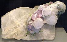 Sebuah mineral putih, dari mana kristal putih dan merah muda pucat menonjol
