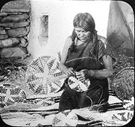 Une femme fabriquant des paniers en 1910.