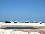 Mini Trucks take people to Land's End, Dhanushkodi, through deep sand and shallows, using planks put under wheels by local kids as the vehicle struggles.