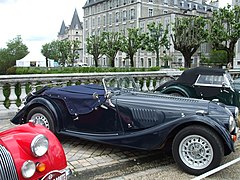 Photographie en couleurs d'une exposition d'anciennes voitures sportives.