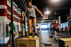 CrossFit antrenmanları içinde yeralan kutu üzerine zıplama hareketi yapan sporcu