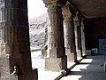 Colonne de temple hindou : massive, ornée de bandeaux horizontaux et des chapiteaux avec des symboles religieux.